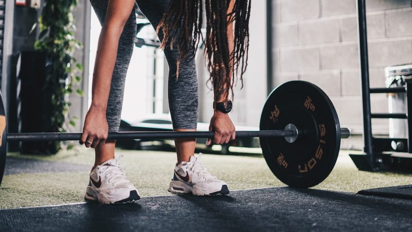 a woman lifting a barbell in a gym